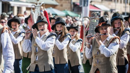 Eine Kapelle in einheitlicher Tracht mit Hemd, Weste und Hut zieht beim Erntedankfestzug der Michaelis-Kirchweih.