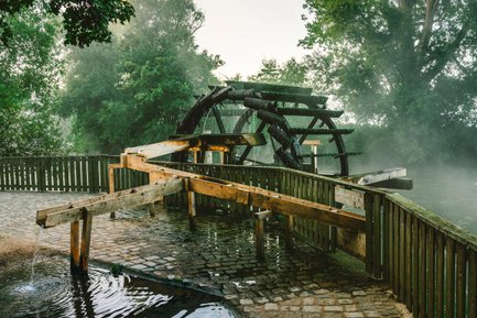 Blick auf das Stadelner Wasserrad, umgeben von grünen Wiesenauen in Fürth, ein malerischer Ort