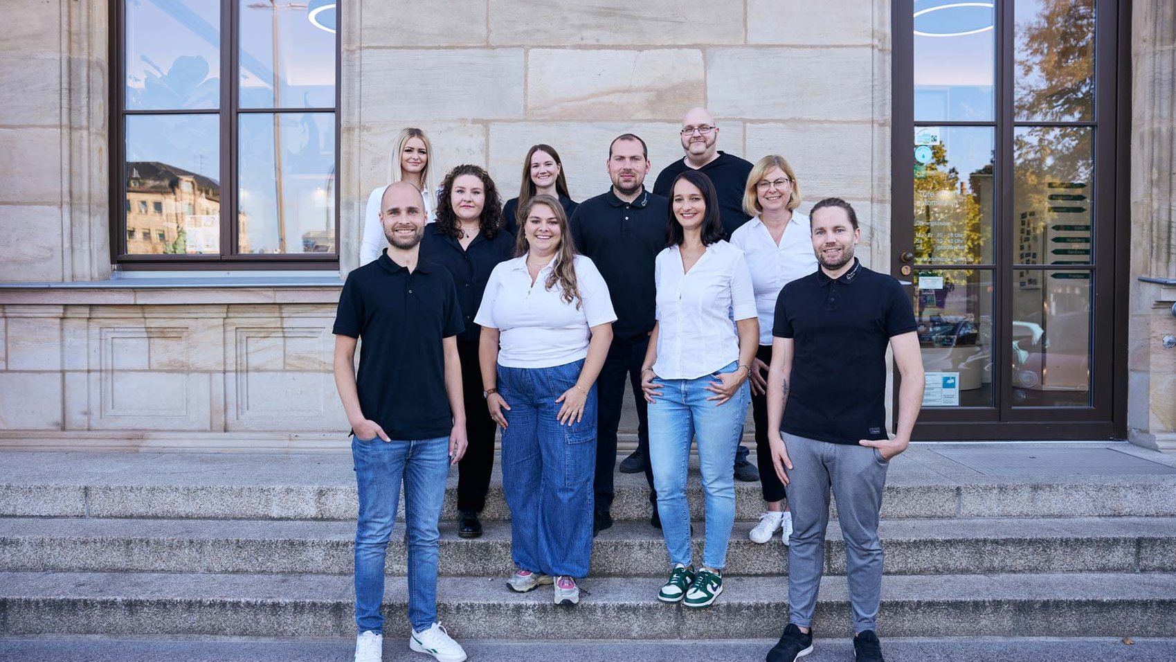 Mitarbeiter:innen der Fürther Tourist-Information stehen vor dem Haupteingang