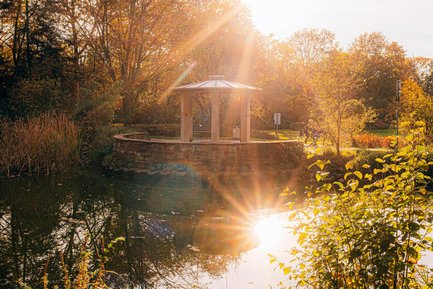 Sonniger Herbsttag an der kleinen Mainau in Fürth, der Pavillon eingebettet in grüner Oase