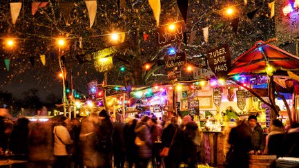 Beleuchteter Mittelaltermarkt in Fürth mit vielen Ständen, Lichtern und Besuchern bei Nacht.