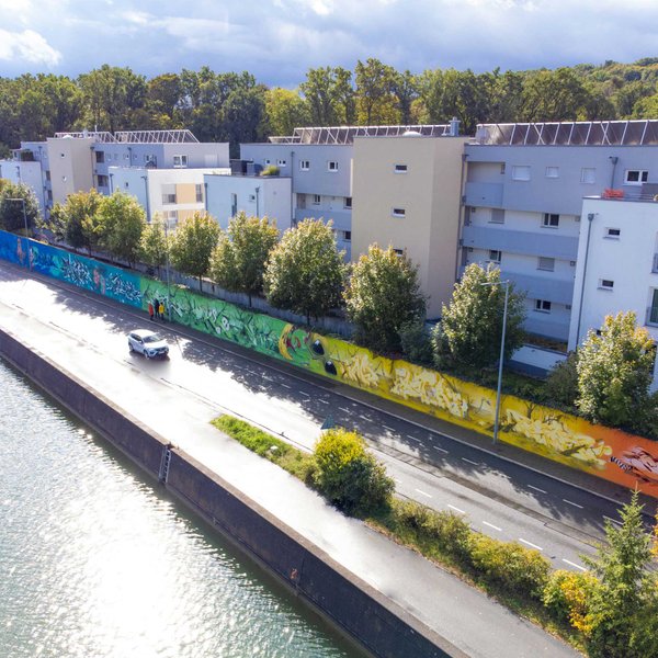 Blick auf das farbenfrohe 250-Meter-Graffiti entlang der Mauer am Grundigpark in Fürth