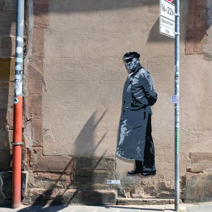 Hausfassade in Fürth mit Stencil-Graffiti eines alten Arbeiters im urbanen Kunststil