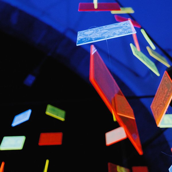 Buntes Acrylglas-Mobile mit quadratischen, leuchtenden Platten und unterschiedlichen Motiven.