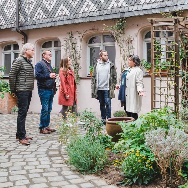 Gruppe im historischen Hof der Fürther Altstadt hört der Stadtführerin bei Erklärungen zu.