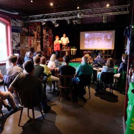 Vortrag in der Kofferfabrik Fürth mit Zuhörerinnen und Zuhörern im warm beleuchteten Musikclub