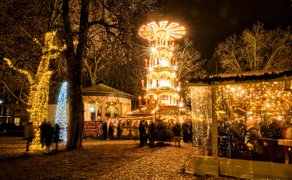 Leuchtende Weihnachtspyramide und gemütlichen Hütten auf dem Weihnachtsmarkt.