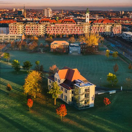 Die Sonne geht über dem Südstadtpark Fürth unter und taucht die grüne Oase in warmes Licht