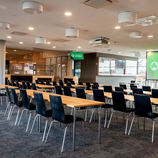 Moderner Tagungsraum auf der VIP-Tribüne im Sportpark Ronhof mit Stuhlreihen, Tischen und Leinwand