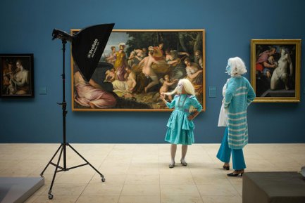 Zwei Frauen mit Masken stehen vor großen historischen Gemälden in Fürth und betrachten sie