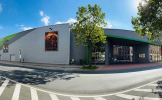 Modernes Cineplex Fürth mit langgezogenem Gebäude, blauem Himmel und einladendem Eingangsbereich