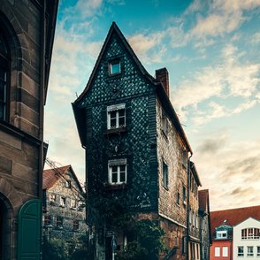 Blick auf den Eingang zur Fürther Pfarrgasse, gesäumt von charmanten Schieferhäusern