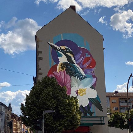 Eisvogel stilvoll mit Blumen an Hauswand in der Fürther Südstadt im Rahmen der Freiluft-Galerie