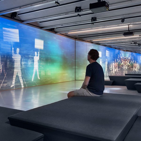 Ein Gast erlebt im Zukunftsraum des Ludwig Erhard Zentrums in Fürth interaktive Medieninstallationen
