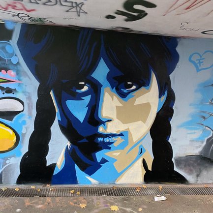 Abstraktes Street-Art-Gemälde von Wednesday Addams an einer legalen Graffiti-Hall in Fürth