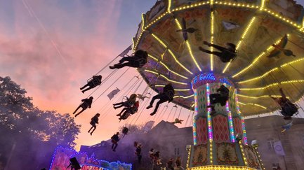 Das Wellenkarussell auf der Michaelis-Kirchweih fährt bunt beleuchtet mit fröhlichen Gästen.