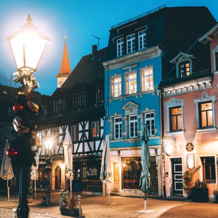 Abendliche Gustavstraße mit charmanten Hausfassaden und dem Turm von St. Michael im Hintergrund